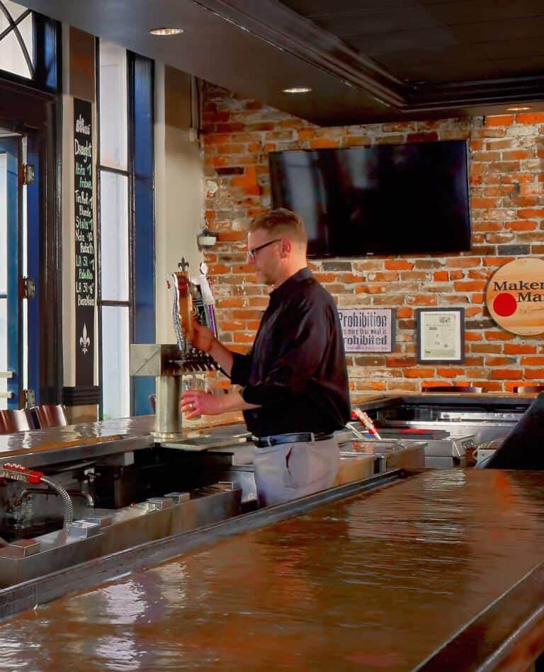 Bartender filling up a glass with beer.