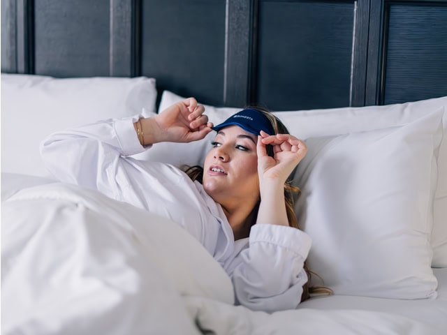 A person waking up in a bed.