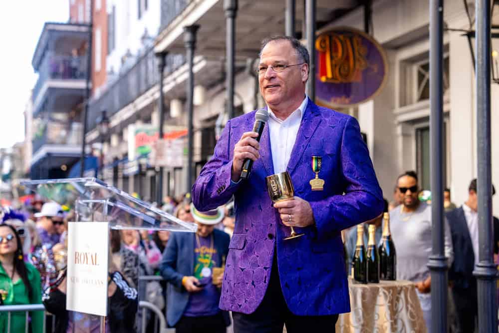 A person with a purple suit speaking at the festival.